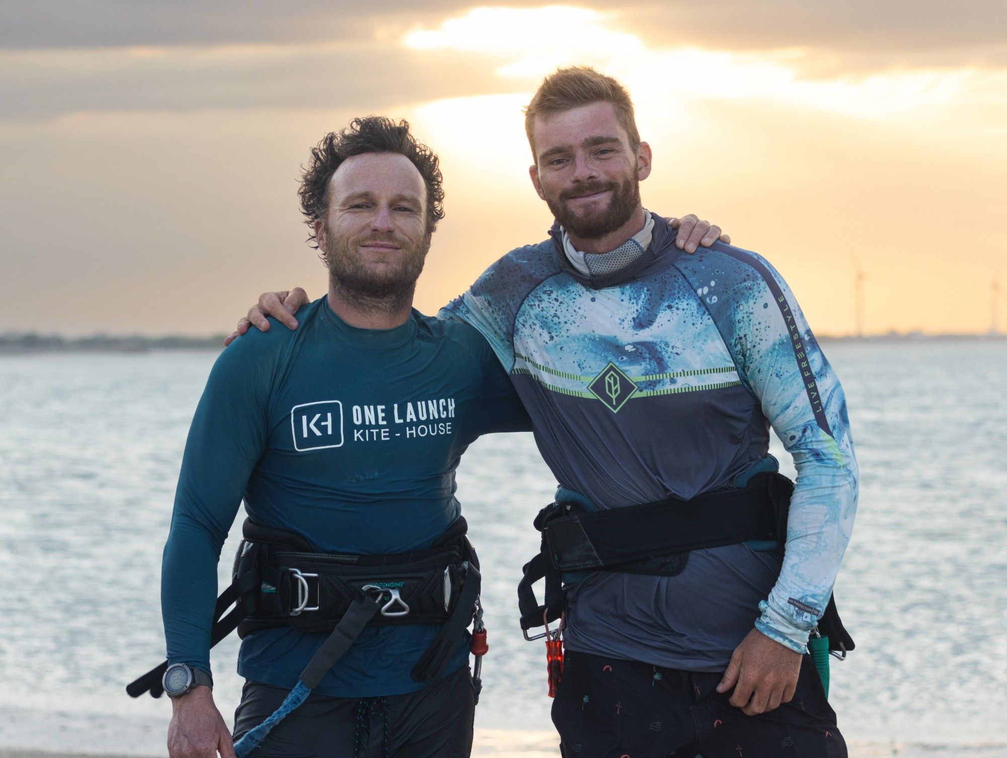 Philippe Ancelin et Pierre, bras dessus bras dessous au bord de l'eau au coucher du soleil